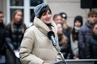 Anastassia Pletoukhina steht am Rednerpult. Im Hintergrund sind Menschen zu sehen.
